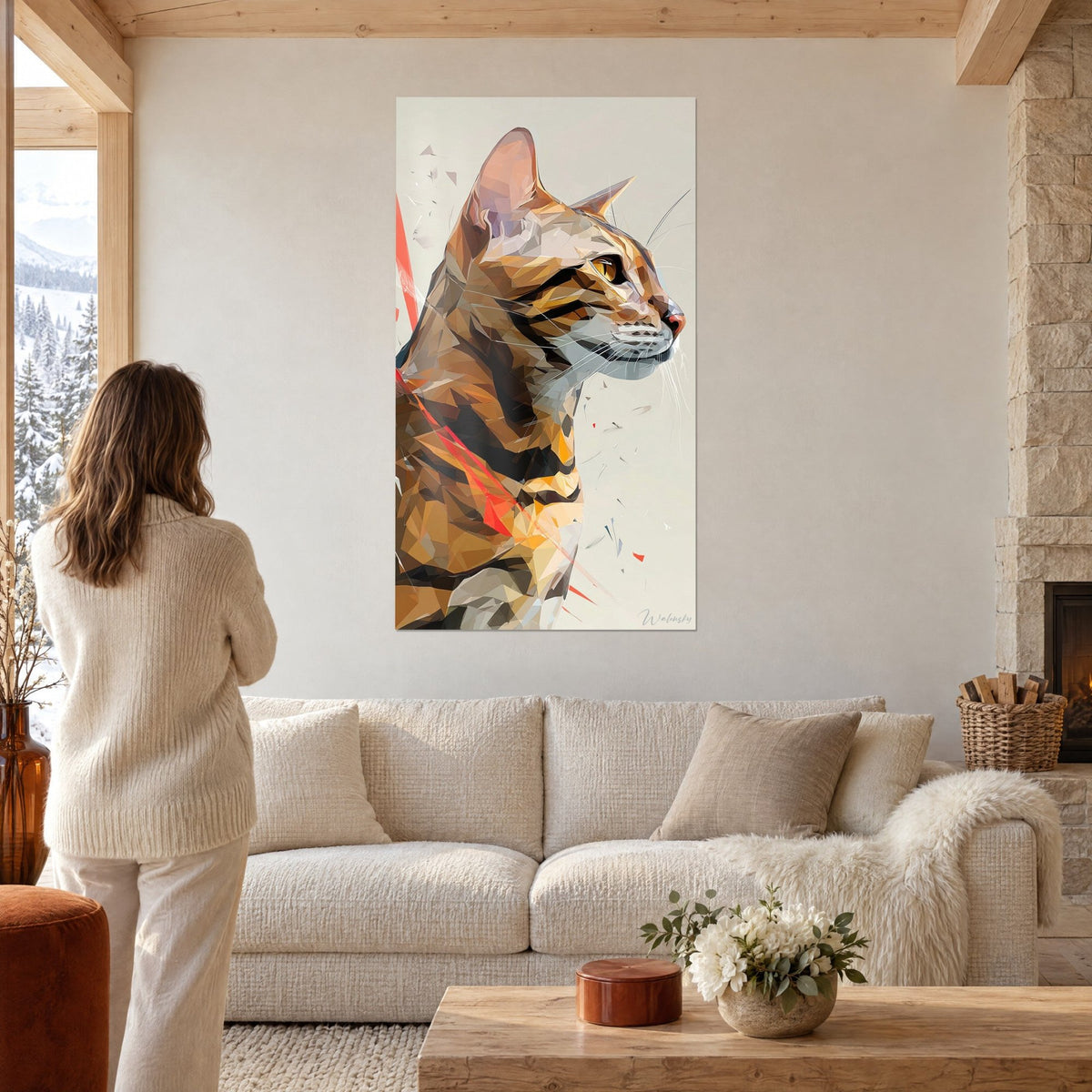 Tableau chat toyger de profil en facettes ocre et rouge corail, femme de dos, au-dessus d'un canapé dans un salon lumineux