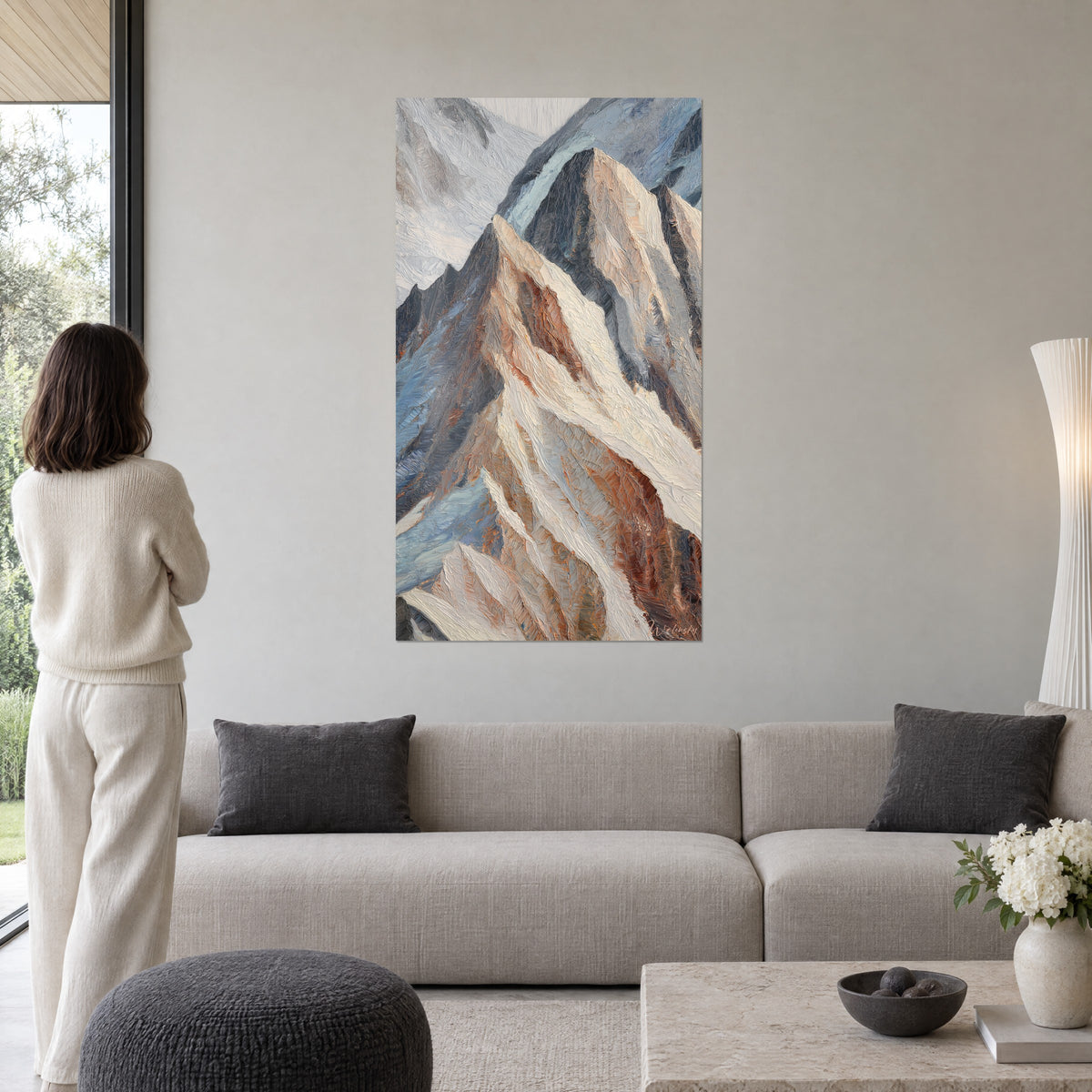 Schilderij van een besneeuwde Pyreneeënkam in paletmesschilderstijl, koperocker en staalblauw, boven een bank in een lichte woonkamer