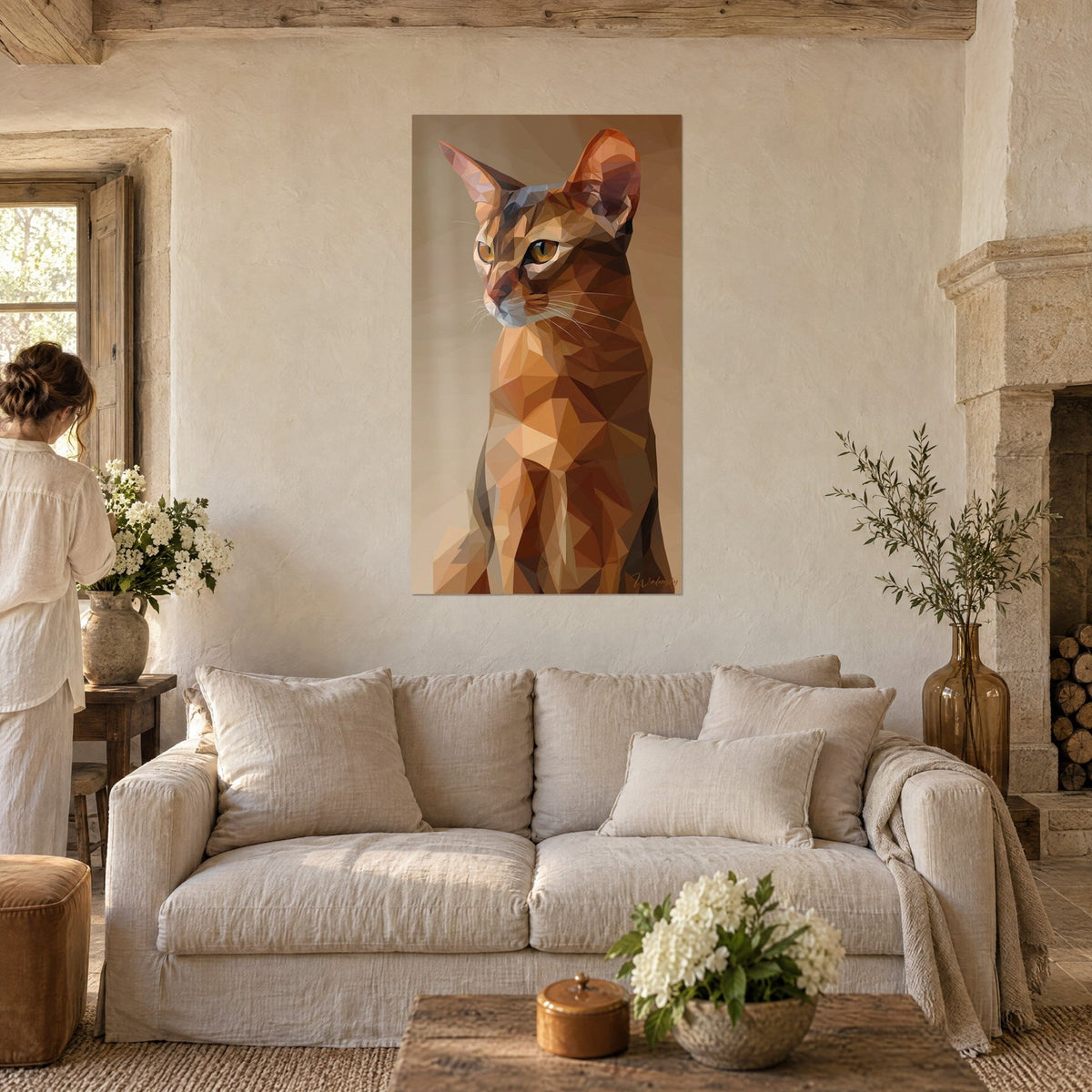 Schilderij Abessijnse kat in koperkleurige en beige facetten, oren rechtop, een vrouw van achteren, boven een bank in een lichte woonkamer