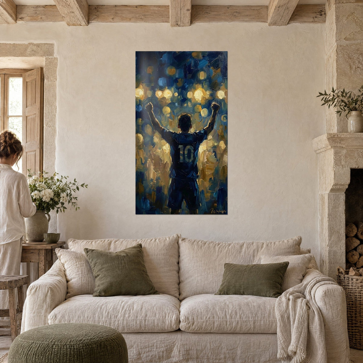 Schilderij voetballer van achteren met opgeheven armen, nachtblauw shirt nummer 10 en gouden halo's, boven een bank in een lichte woonkamer