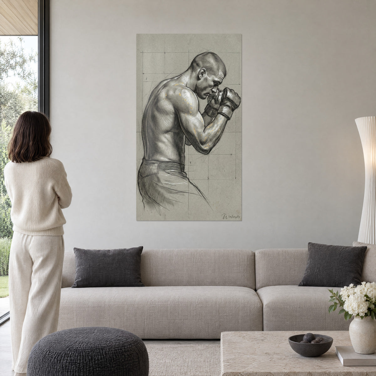 Quadro di un pugile di profilo, pugni guantati alzati, carboncino grigio con tocchi d'oro, una donna di spalle sopra un divano in un soggiorno luminoso