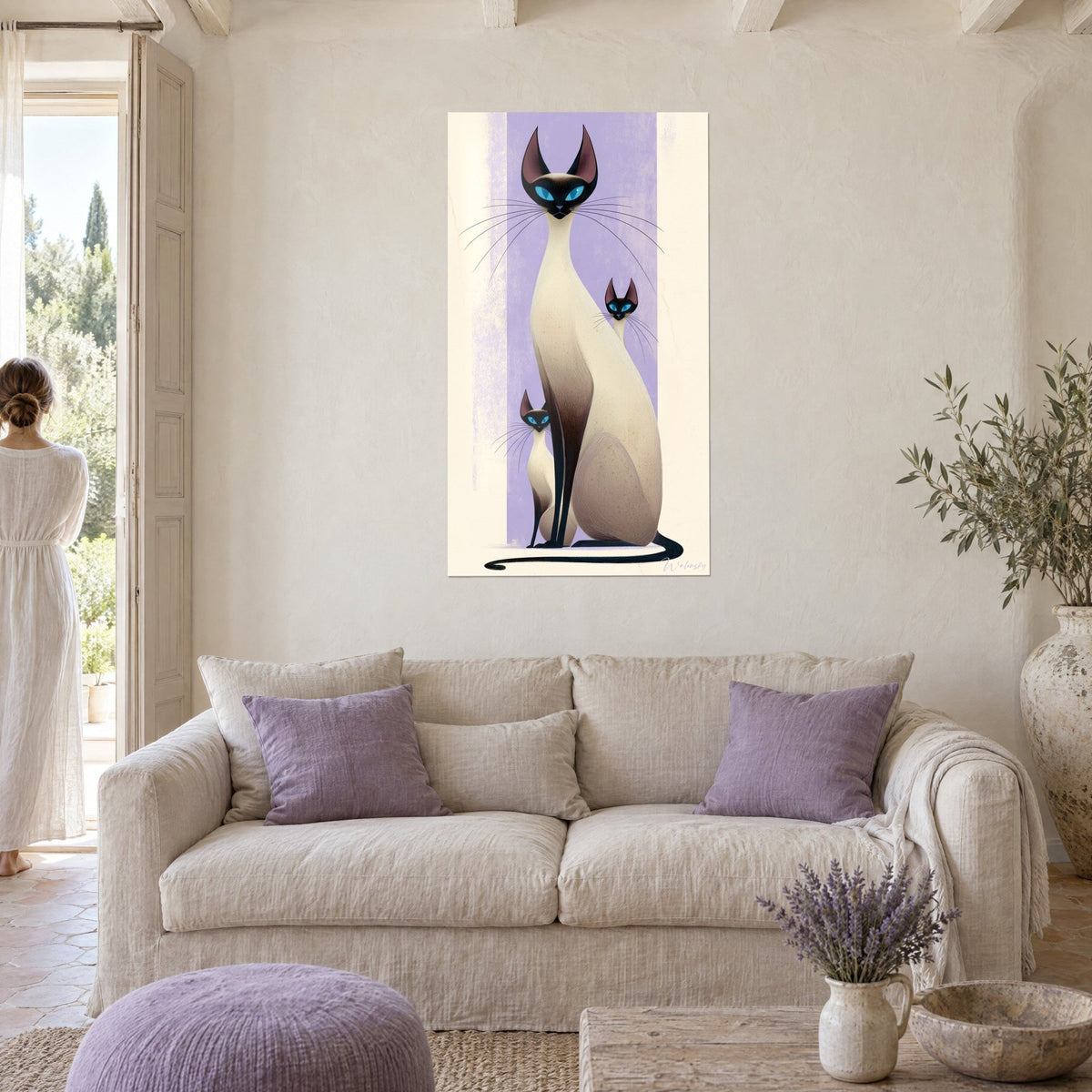 Wall art slender Siamese cat with blue eyes, lilac stripe and cream background, two kittens at her feet, above a sofa in a bright living room