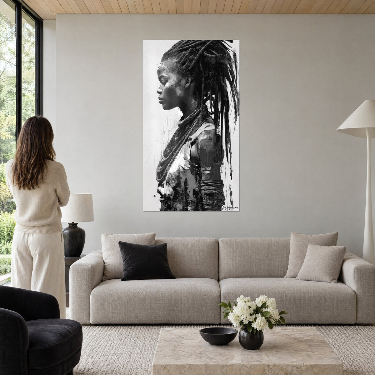 Cuadro perfil de mujer africana con rastas, en blanco y negro rayado, frente a un dúo de espaldas, sobre un sofá en un salón luminoso