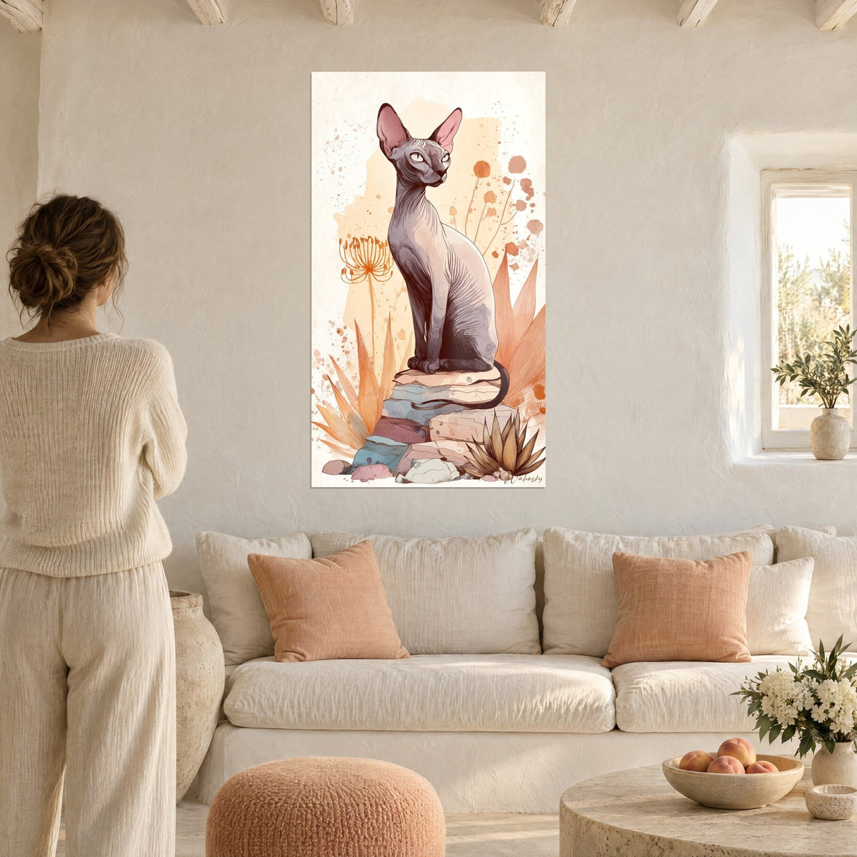 Tableau chat Sphynx assis sur des pierres pastel, fleurs orange et feuilles ocre, femme de dos au-dessus d'un canapé dans un salon lumineux