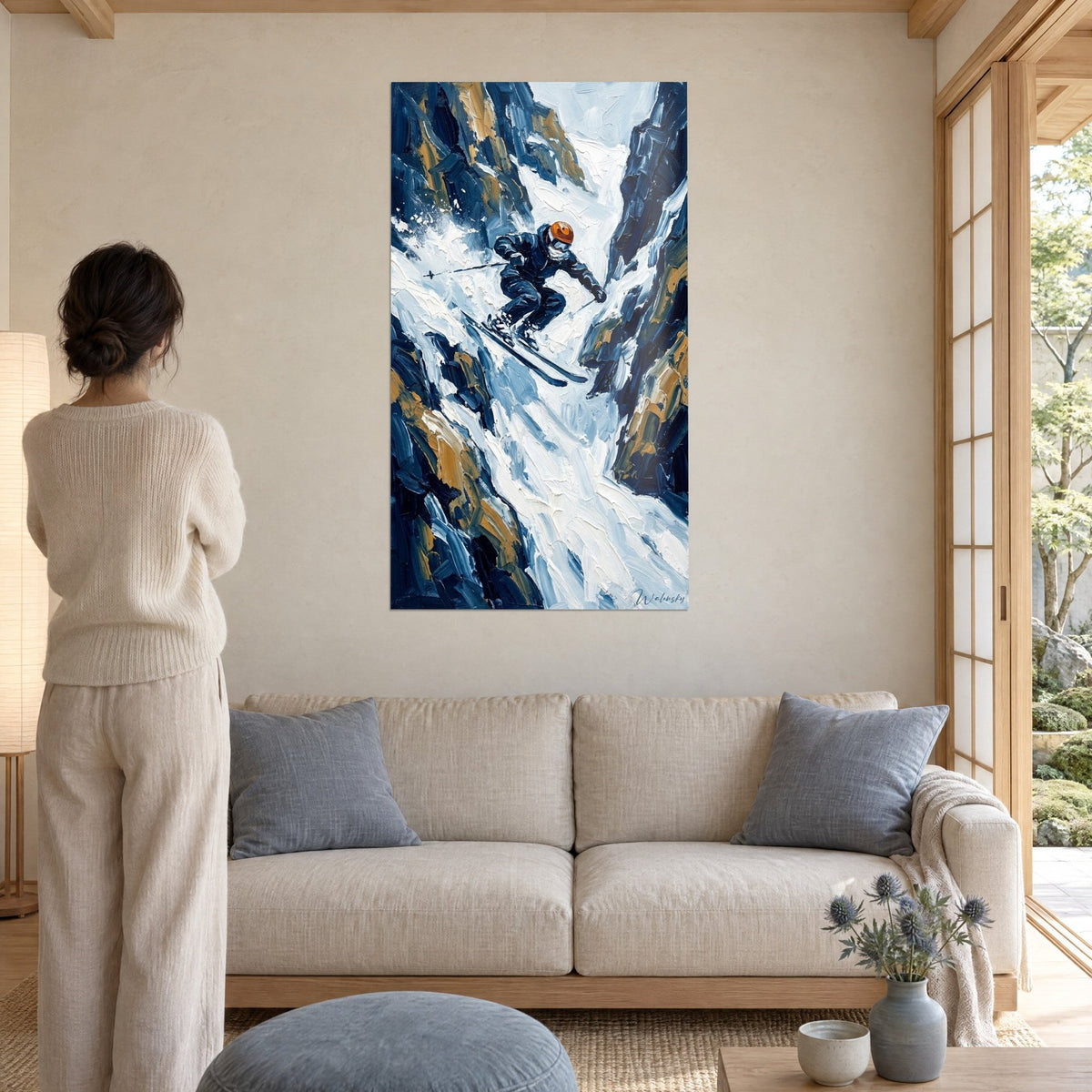 Quadro sciatore freestyle in tuta blu notte e casco arancione che scende un canalone ocra, sopra un divano in un soggiorno luminoso