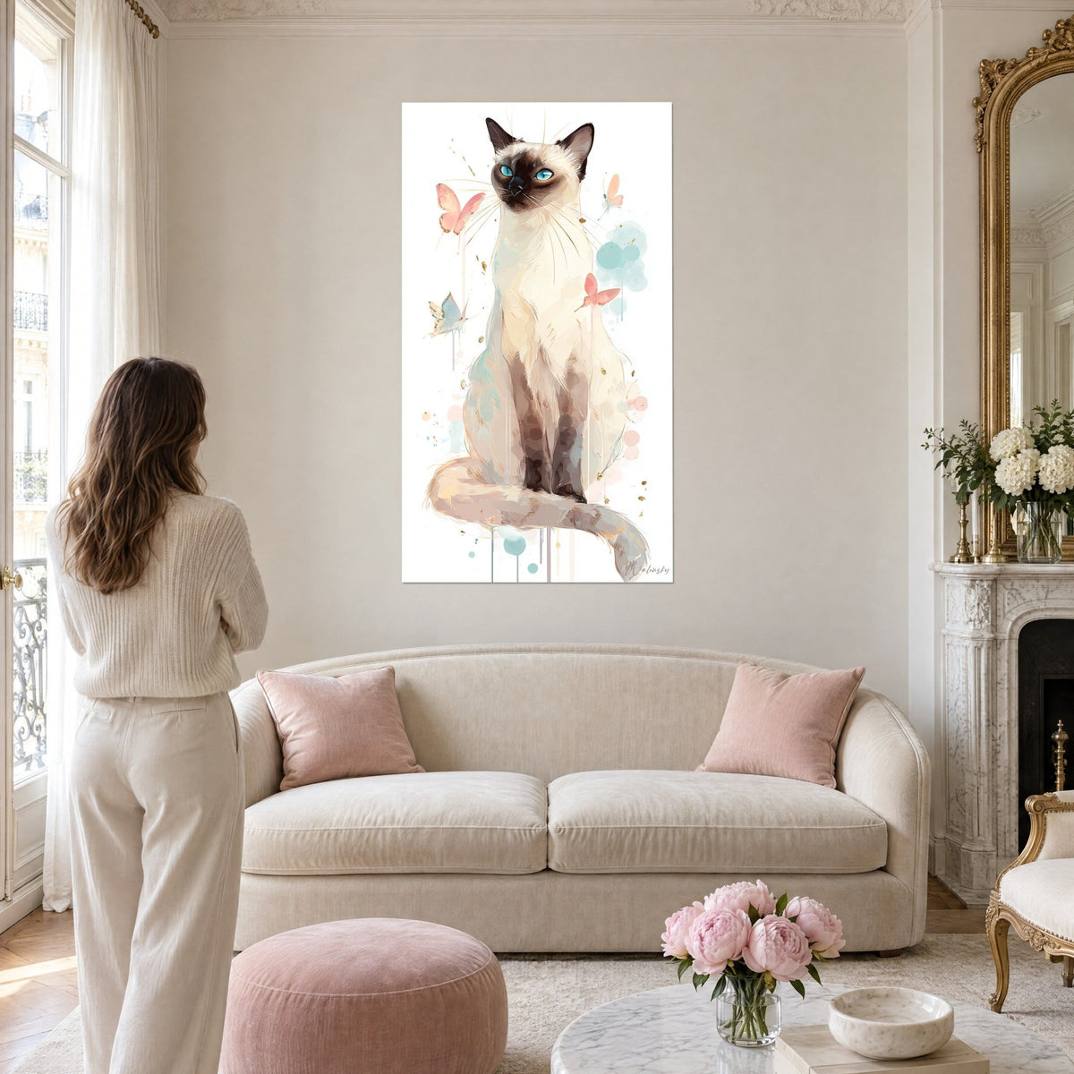 Tableau chat balinais aux yeux turquoise, pelage crème et pattes brun foncé, papillons roses, au-dessus d'un canapé dans un salon lumineux