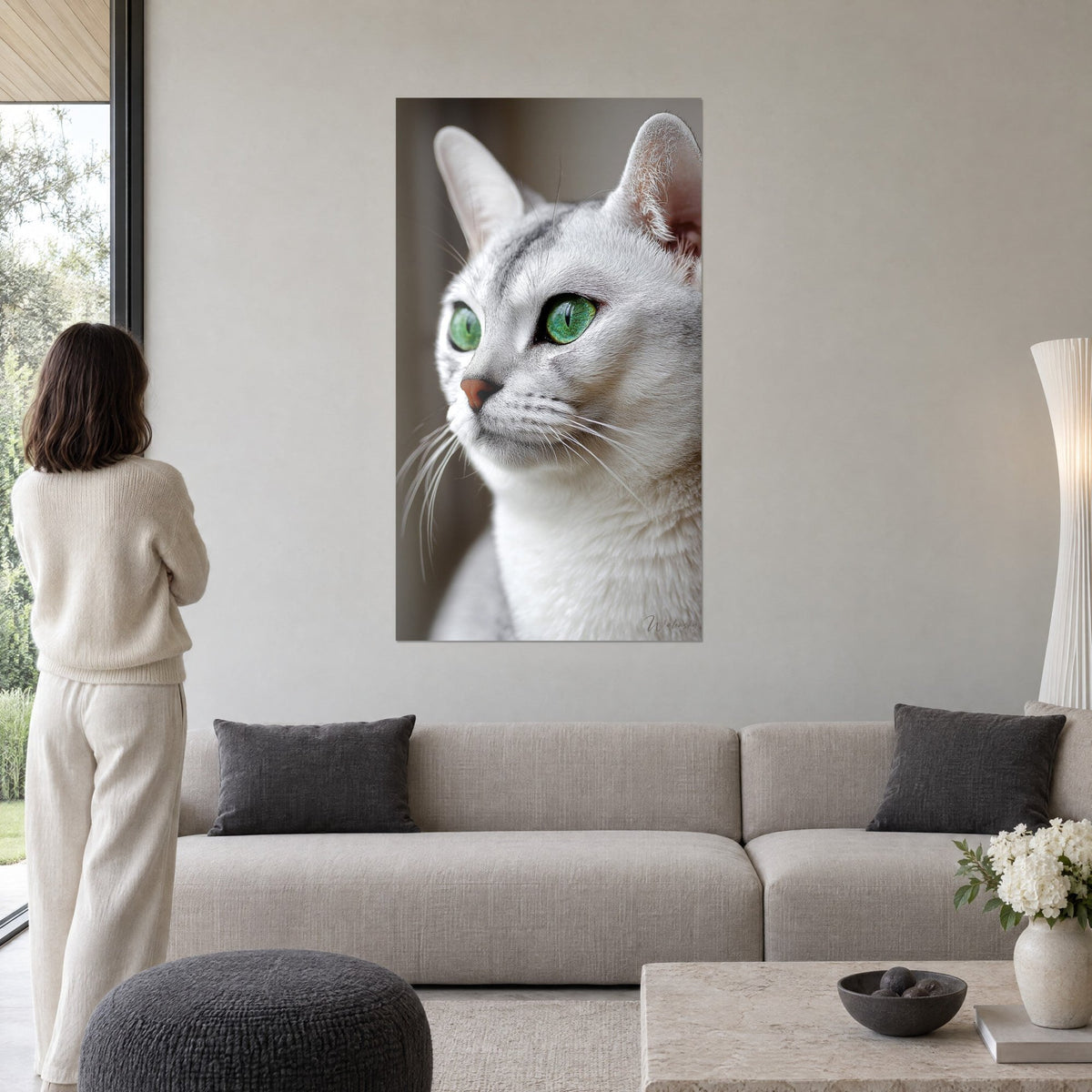 Schilderij Burmilla-kat met zilverkleurige vacht en smaragdgroene ogen, trots profiel, vrouw van achteren, boven een bank in een lichte woonkamer