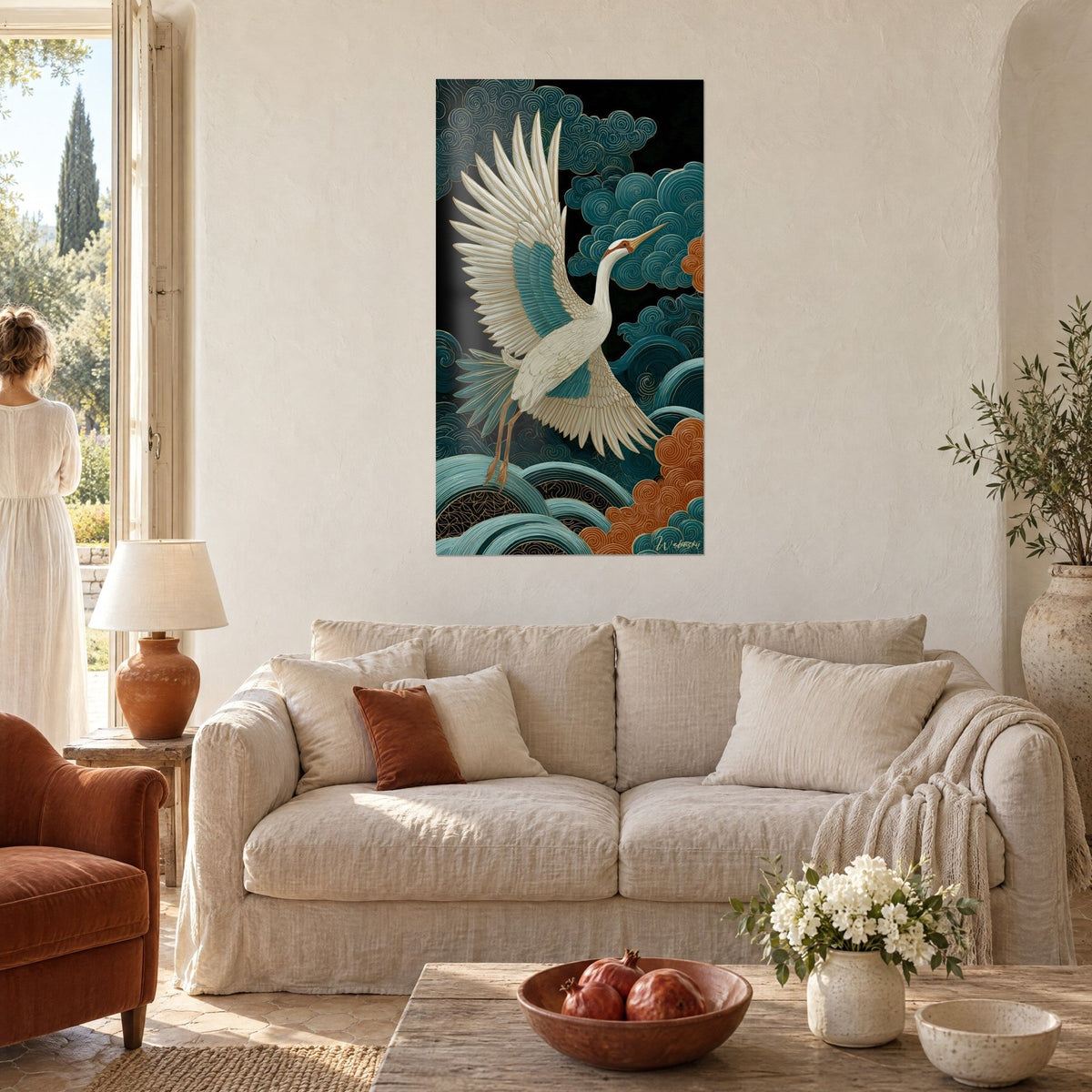 Gemälde Weißer Kranich mit ausgebreiteten Flügeln vor türkisfarbenen und kupferfarbenen Wolken, Frau von hinten, über einem Sofa in einem hellen Wohnzimmer