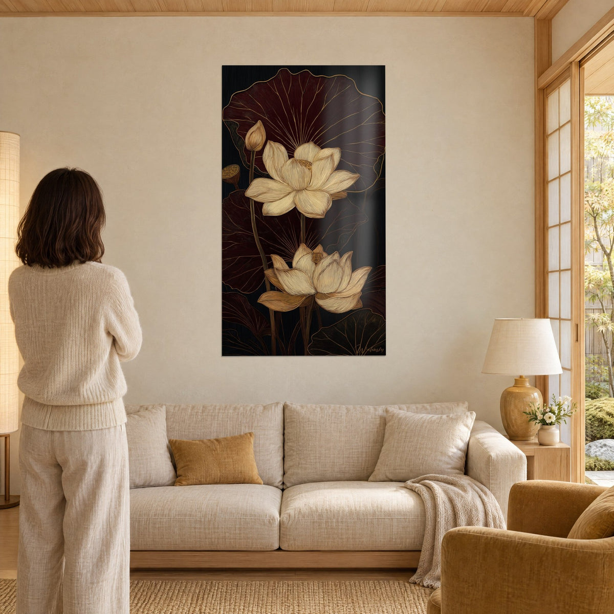 Wall art of a cream lotus in full bloom over burgundy leaves veined in gold, black frame, above a sofa in a bright living room