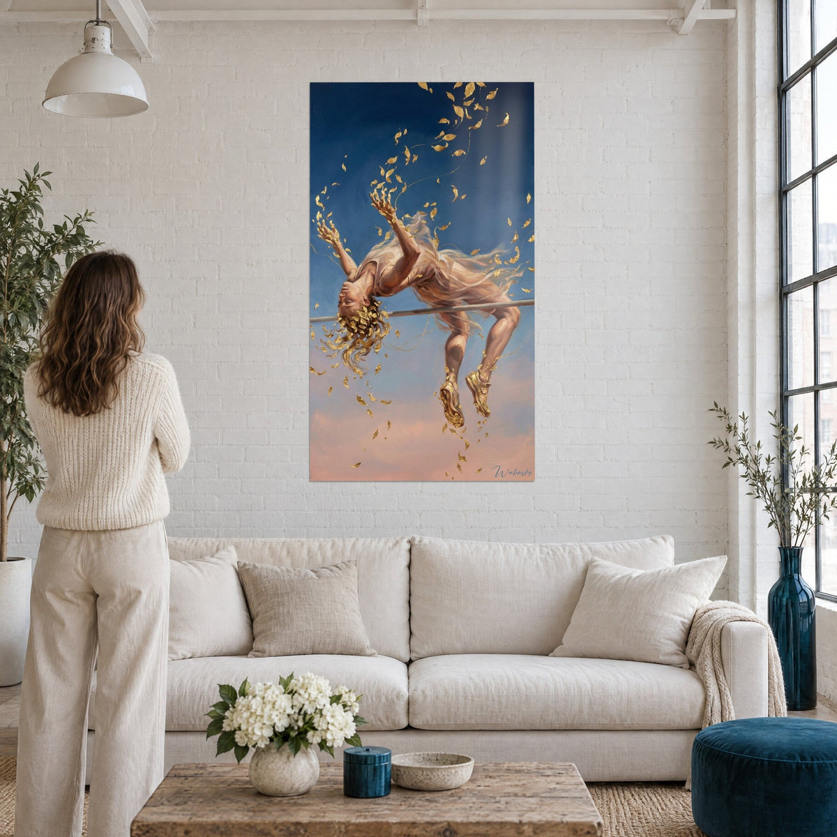 Schilderij hoogspringen in gebogen houding, lichtroze jurk, gouden bladeren tegen een nachtblauwe hemel, boven een bank in een lichte woonkamer