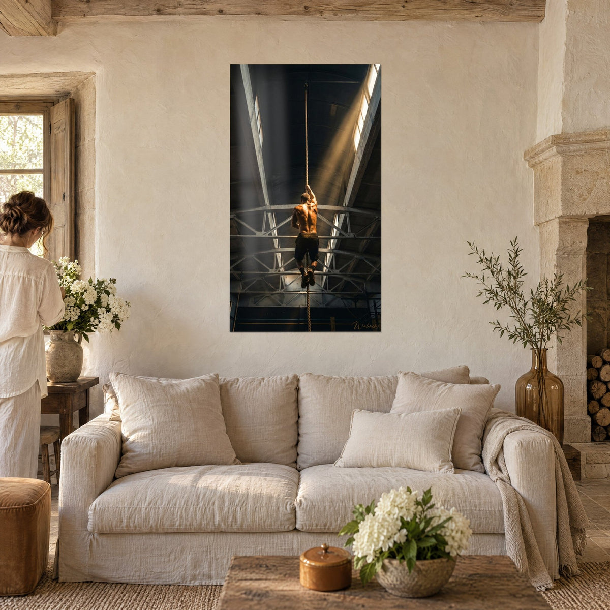 Wall art shirtless athlete climbing a rope, golden light beam, black steel beams, above a sofa in a bright living room