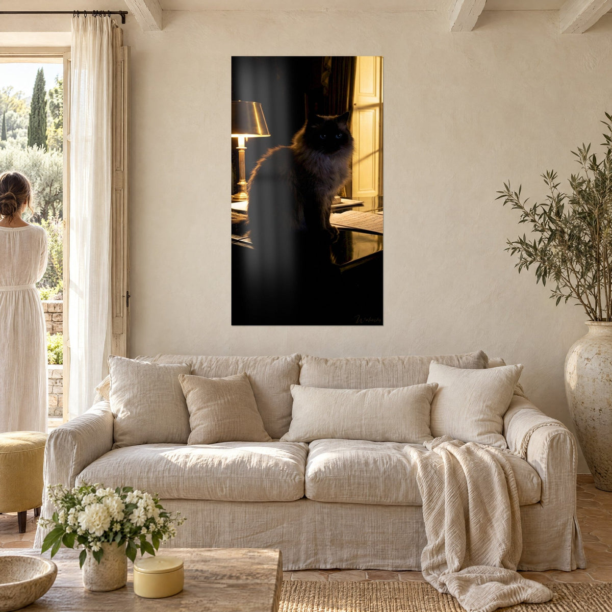 Schilderij Himalaya-kat als donkere silhouet naast een gouden lamp, blauwe ogen, ivoorkleurige muren, boven een bank in een lichte woonkamer
