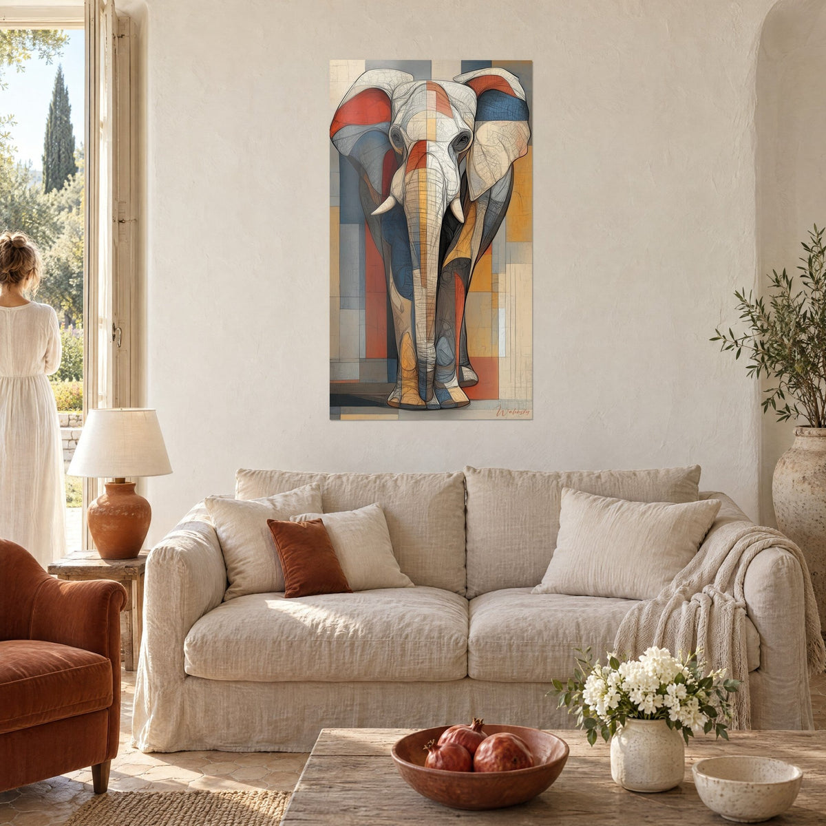 Wall art African elephant in a geometric mosaic of brick red and slate blue, ears spread wide, above a sofa in a bright living room