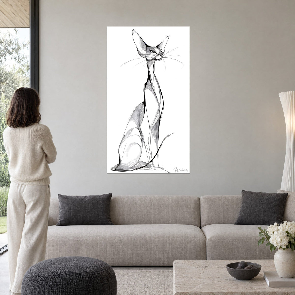 Tableau chat siamois filiforme aux grandes oreilles, traits noirs sur fond blanc, au-dessus d'un canapé dans un salon lumineux