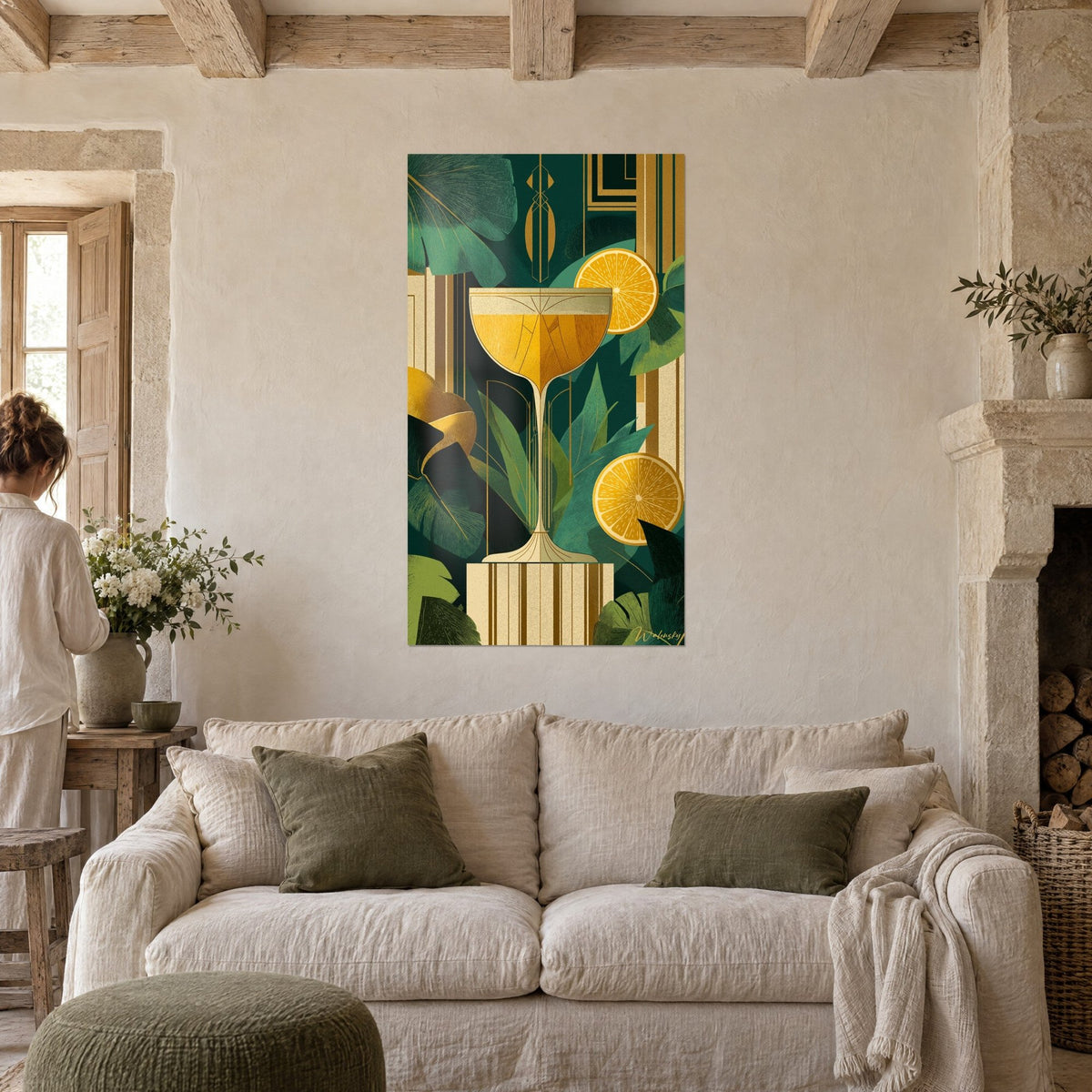 Wall art of an amber cocktail glass between emerald leaves and gold orange slices, above a sofa in a bright living room
