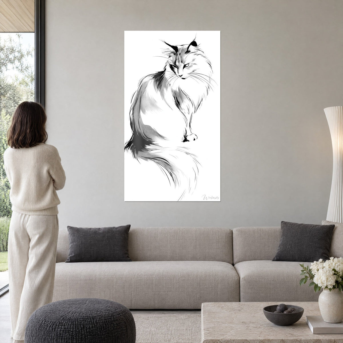 Cuadro gato siberiano en tinta negra y gris sobre fondo blanco, pelaje revuelto, mujer de espaldas, encima de un sofá en un salón luminoso