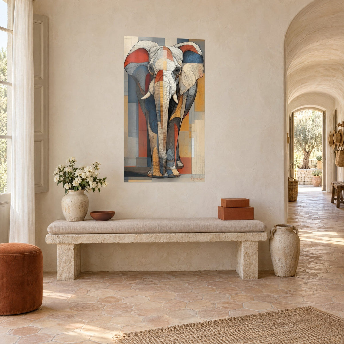 Wall art pachyderm with ivory tusks, ochre and blue-grey blocks of colour, hung on a whitewashed wall beside a pale stone arch