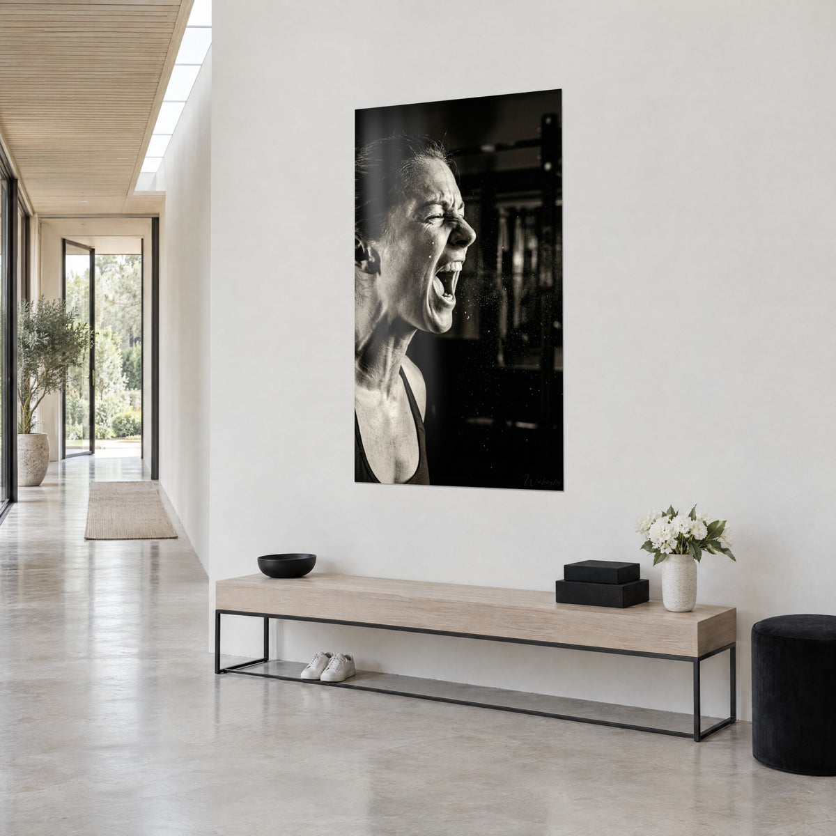 Tableau portrait de sportive en plein cri, peau ivoire et fond noir profond, accroché au-dessus d'un banc en bois clair