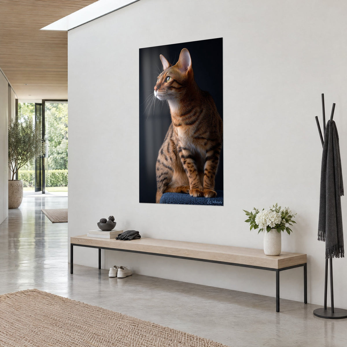 Cuadro felino atigrado cobrizo sentado bien erguido, orejas levantadas, hocico rosa y fondo azul noche, en un pasillo claro de tres cuartos