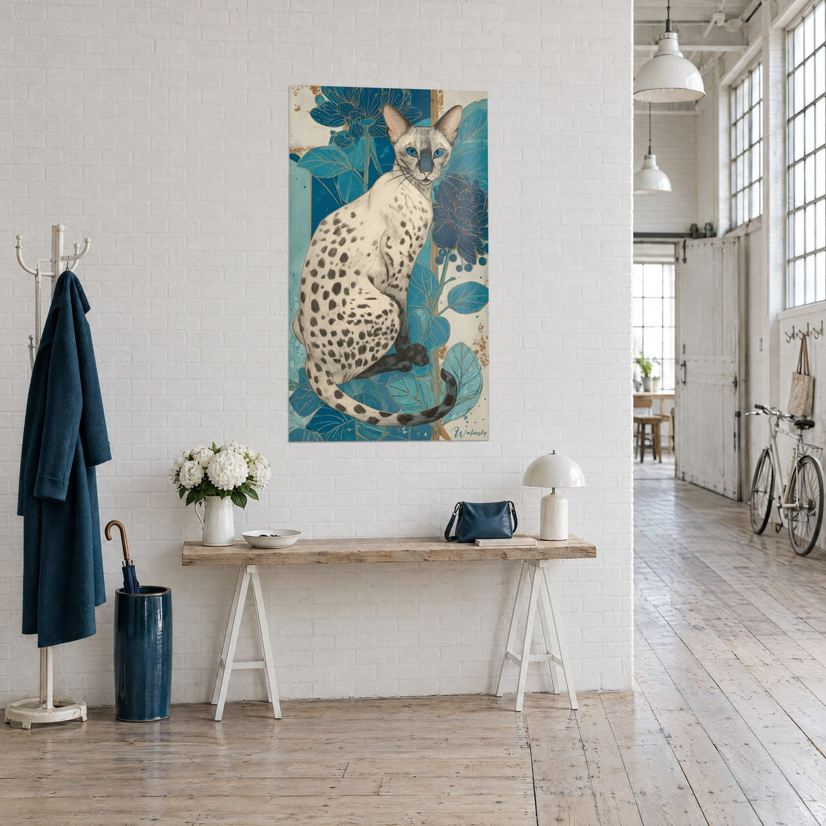 Gemälde schlanke cremefarbene Katze mit schwarzen Flecken, petrolblauer Hintergrund und Goldakzente, an einer weißen Wand eines Künstlerlofts