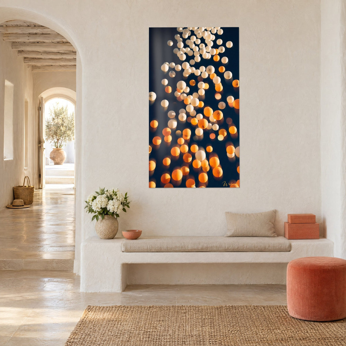 Wall art with a rain of ivory and orange celluloid balls floating in shadow, arched white niche in a Mediterranean home
